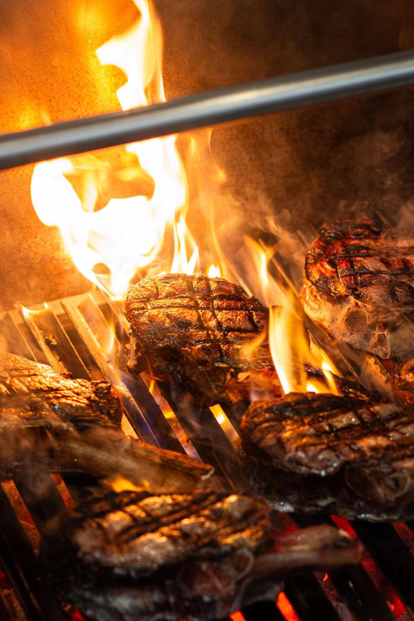Steaks op de houtskoolgrill, met de tang erbij