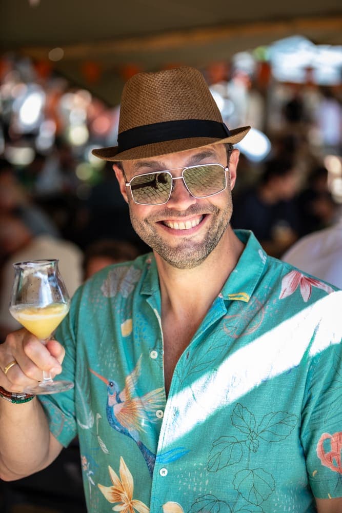 Een bezoeker met hoed en zonnebril heft zijn glas op Taphorst '26