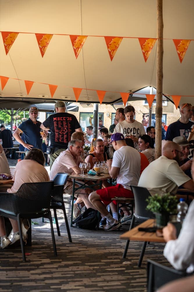 Bezoekers onder de tent met oranje vlaggetjes op Taphorst '26