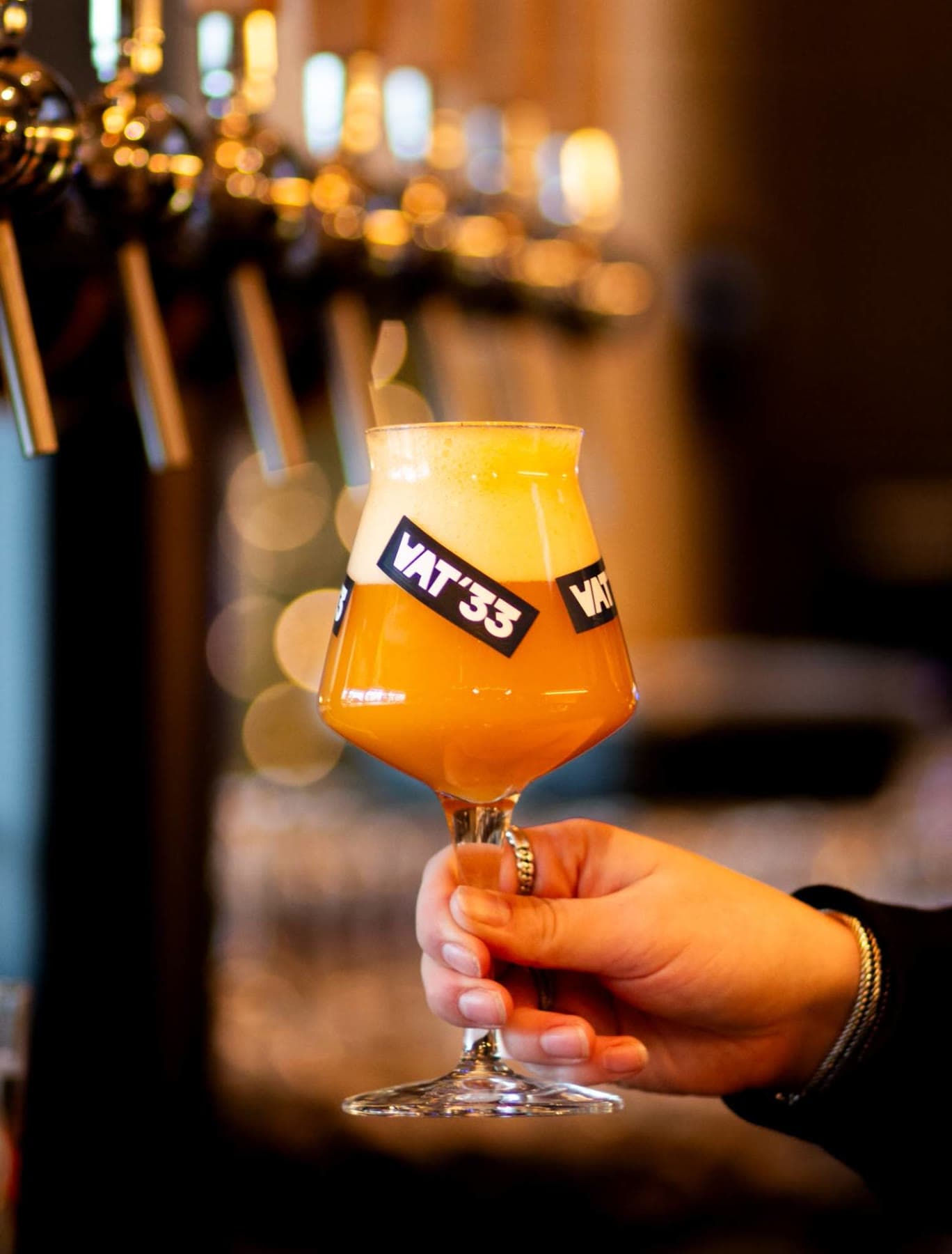 Een VAT'33-glas vol hazy IPA voor de tapwand van Tjaps